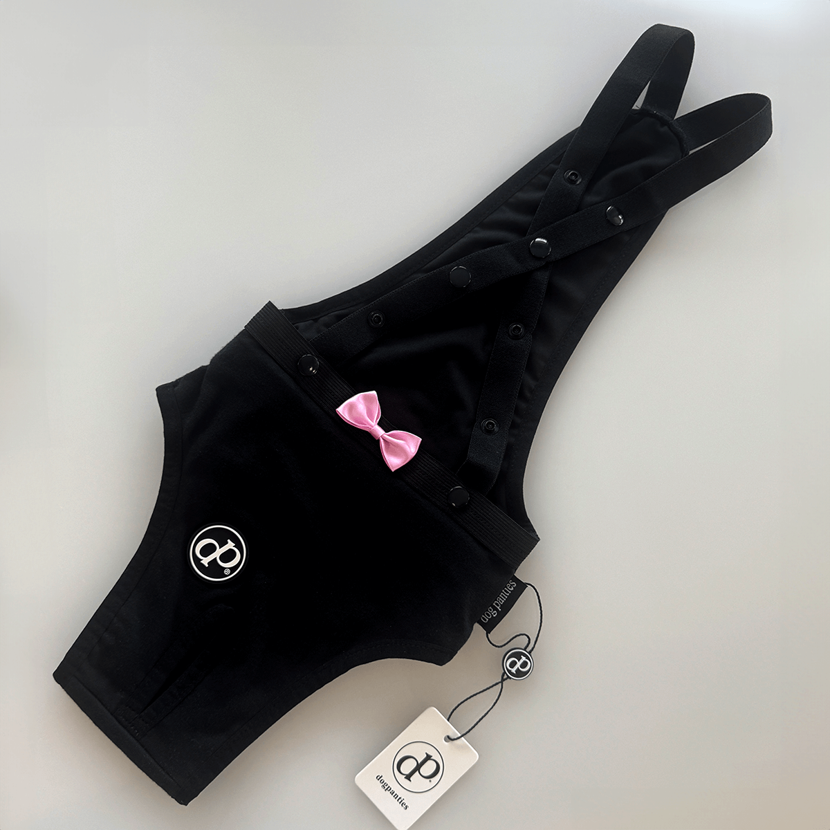 Hygiene Panties for Dogs - Black DogPanties® with adjustable suspenders and pink bow decoration.