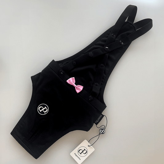 Hygiene Panties for Dogs - Black DogPanties® with adjustable suspenders and pink bow decoration.